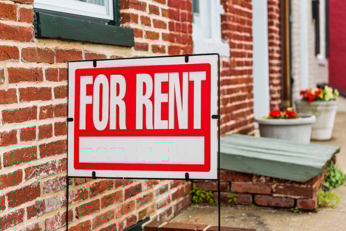 Rent sign closeup against brick building